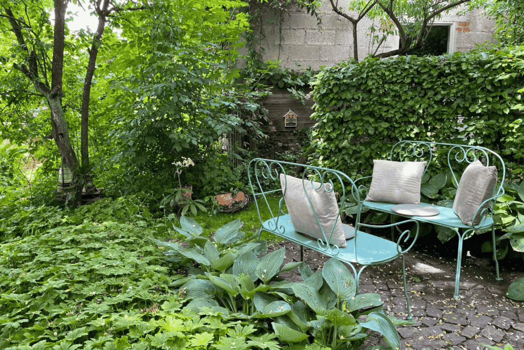 Rückzugsort im Schatten, umgeben von üppigen Stauden wie Hosta und Geranium – ein Platz zum Durchatmen im Grünen.