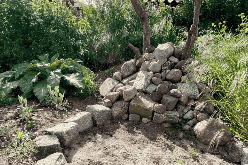 Selbst gebaute Reptilienburg aus Natursteinen im naturnahen Garten