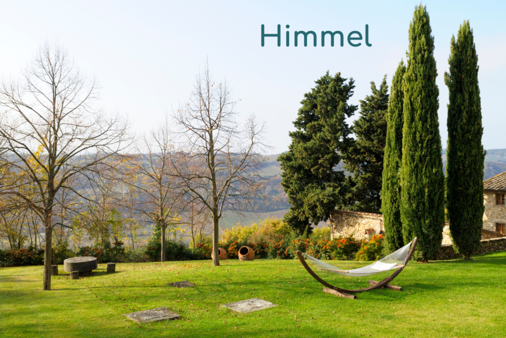 Eine Hängematte auf einer weiten Rasenfläche mit Blick auf eine offene Hügellandschaft.