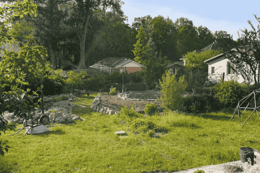 Garten vor der Umgestaltung  – großer Rasen ohne Struktur; mit der Feuerstelle wurde bereits begonnen