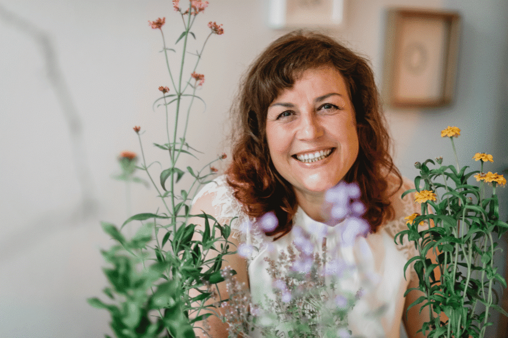 Sadhana Kraus, Gartenberaterin bei Flower Power, am Schreibtisch umgeben von Wildblumen