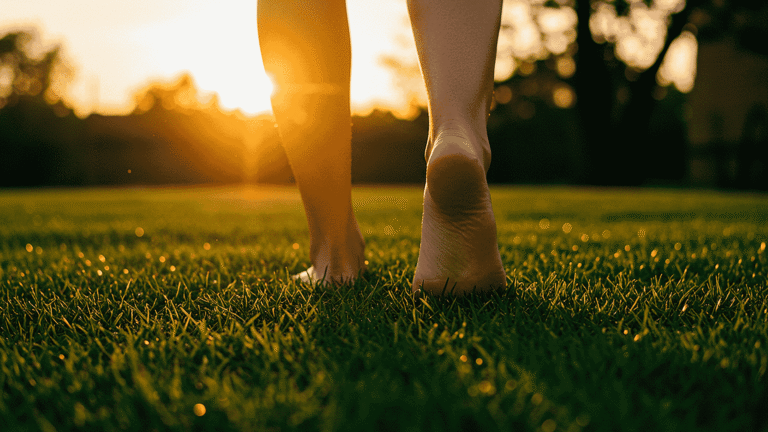 zwei nackte Beine die auf taufrischem grünen Rasen laufen