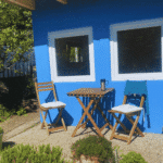 Blau gestrichene Gartenlaube mit Sitzplatz im Schrebergarten